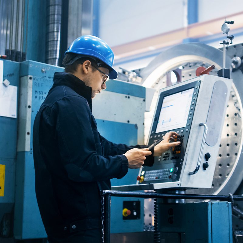 Worker Using a CNC Machine for Die Cutting